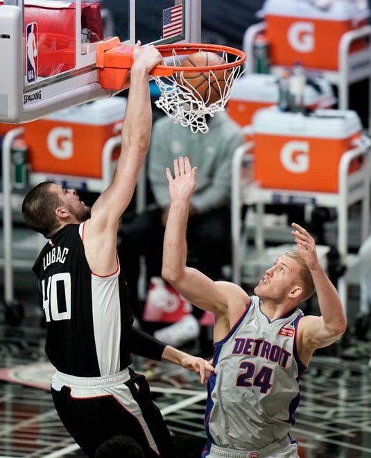 Los Angeles Clippers' Ivica Zubac, left, dunks over Detroit Pistons' Mason Plumlee during the first half of an NBA basketball game Sunday, April 11, 2021, in Los Angeles.