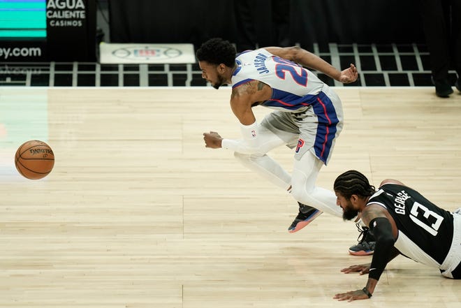 Los Angeles Clippers' Paul George, right, watches as Detroit Pistons' Josh Jackson chases the ball during the first half of an NBA basketball game Sunday, April 11, 2021, in Los Angeles.