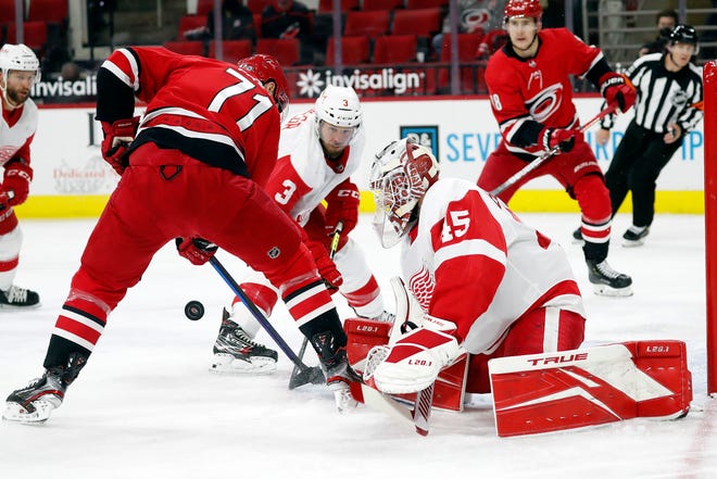 Carolina Hurricanes' Jesper Fast (71) tries to gather in the puck in front of Detroit Red Wings goaltender Jonathan Bernier (45) and Alex Biega (3) during the second period of an NHL hockey game in Raleigh, N.C., Monday, April 12, 2021.
