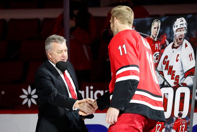 Carolina Hurricanes' Jordan Staal (11) shakes hands with Hurricanes GM Don Waddell during a pre-game ceremony recognizing his 1000 career game prior to the first period of an NHL hockey game between the Carolina Hurricanes and the Detroit Red Wings in Raleigh, N.C., Monday, April 12, 2021.