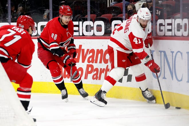 Detroit Red Wings' Luke Glendening (41) controls the puck in front of Carolina Hurricanes' Martin Necas (88) during the second period.