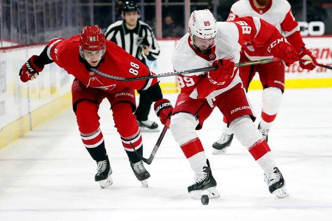 Detroit Red Wings' Sam Gagner (89) tries to gather in the puck in front of Carolina Hurricanes' Martin Necas (88) during the first period.