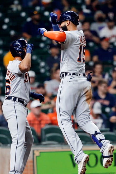 Detroit Tigers' Jeimer Candelario, left, and Nomar Mazara (15) celebrate at the plate after they scored Mazara's home run against the Houston Astros during the fourth inning of a baseball game Tuesday, April 13, 2021, in Houston.