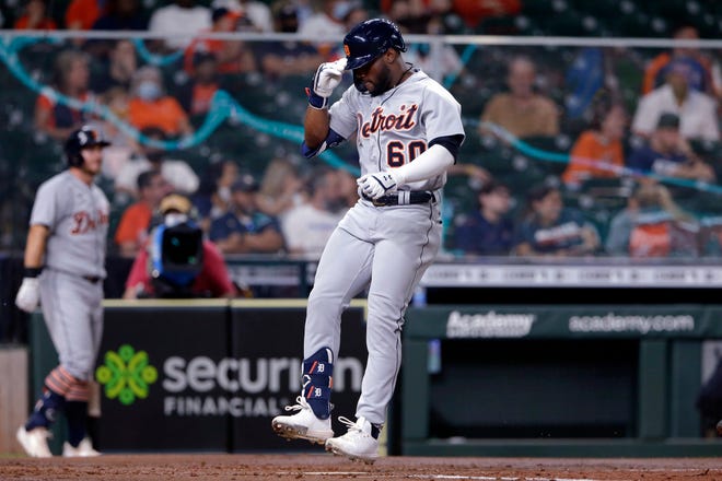 Detroit Tigers' Akil Baddoo (60) jumps onto home plate as he scores on his home run during the third inning of the team's  baseball game against the Houston Astros Tuesday, April 13, 2021, in Houston.
