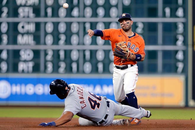 Houston Astros second baseman Jose Altuve, right, throws over Detroit Tigers' Jeimer Candelario (46) to complete a double play on Wilson Ramos during the seventh inning of a baseball game Tuesday, April 13, 2021, in Houston.