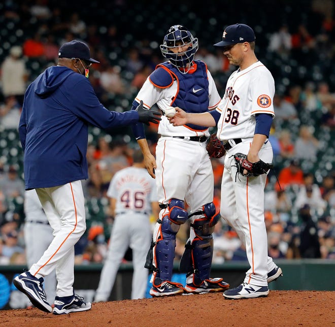 Joe Smith #38 of the Houston Astros hands the ball to manager Dusty Baker Jr. #12 as he is removed in the fourth inning against the Detroit Tigers at Minute Maid Park on April 14, 2021 in Houston, Texas.