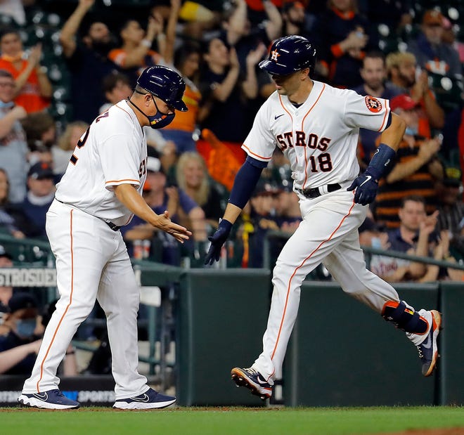 Jason Castro #18 of the Houston Astros receives congratulations from third base coach Omar Lopez #22 after hitting a two-run home run in the fifth inning against the Detroit Tigers at Minute Maid Park on April 14, 2021 in Houston, Texas.