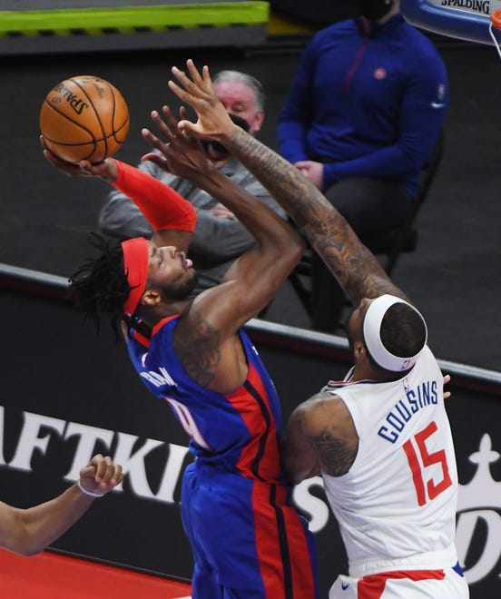 Pistonss' Jerami Grant drives on Clippers' DeMarcus Cousins in the first quarter.