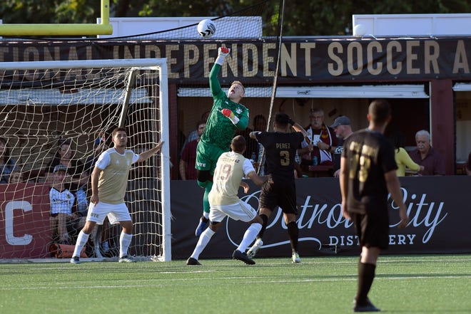Detroit City FC goalkeeper Nate Steinwascher, top, leaps to punch away a shot attempt by the L.A. Force in the first half.