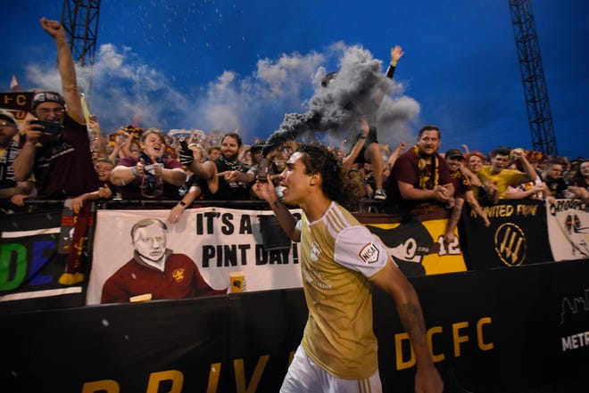 Detroit City FC's Maxi Rodriguez celebtrates with fans as he runs past them with a can of smoke Saturday, July 3, 2021.