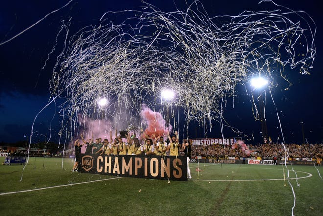 The Detroit City FC team celebrate with the trophy after winnning against the L.A. Force 1-0, Saturday, July 3, 2021, during the NISA Spring Championship game held at Keyworth Stadium in Hamtramck, Mich.