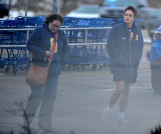 Two unidentified people leave the Meijer store in Oxford where parents were instructed to pick up their children after a mass shooting at Oxford High School on Tuesday, Nov. 30, 2021.