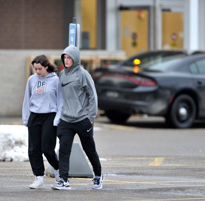 Two unidentified people leave the Meijer store in Oxford where parents were instructed to pick up their children after the active shooter incident at Oxford High School, Tuesday afternoon, November 30, 2021.