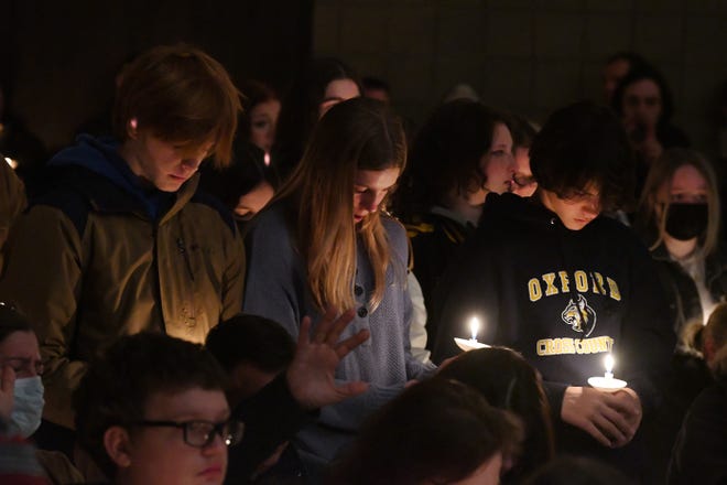 Oxford High School students Max Myrand, 15, Ella Sharrow, 14 and Alex Mcarthur, 15 at the candlelight vigil at LakePoint Community Church in Oxford on Tuesday, Nov. 30, 2021.