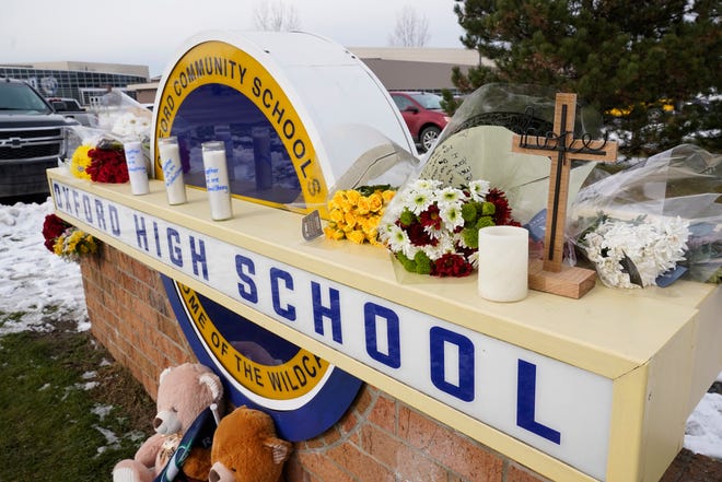 Memorial items are shown on the sign of Oxford High School in Oxford on Wednesday, Dec. 1, 2021. Ethan Crumbley, a 15-year-old sophomore, is accused of opening fire at the school, killing four students and wounding seven others, including a teacher.