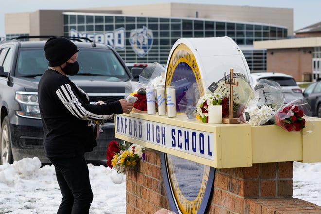 A well wisher leaves a stuffed animal at a memorial on the sign of Oxford High School on Wednesday, Dec. 1, 2021, a day after four students were killed and seven others, including a teacher, were wounded in a mass shooting.