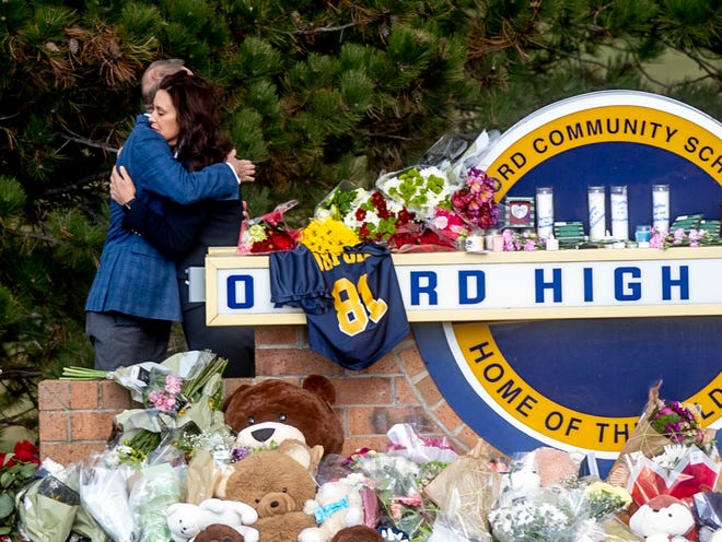Gov. Gretchen Whitmer embraces Oakland County Executive Dave Coulter as the two leave flowers and pay their respects Thursday morning, Dec. 2, 2021 at Oxford High School in Oxford, Mich. A 15-year-old boy has been denied bail and moved to jail after being charged in the Michigan school shooting that killed four students and injured others.