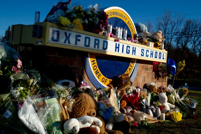 Family, friends, students and relatives of victims put up bouquets of flowers, candles and personalized messages at a memorial near an entrance to the Oxford High School on Thursday, Dec. 2, 2021 in Oxford, Mich.  A 15-year-old boy has been denied bail and moved to jail after being charged in the Michigan school shooting that killed four students and injured others.