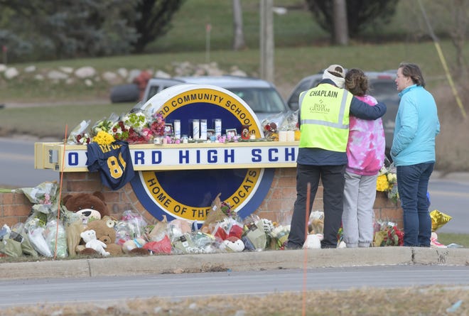 A Chaplin hugs a student at a memorial at the entrance to Oxford High School on Thursday, December 2, 2021as the students, parents, and the community mourn the students shot and killed on campus.