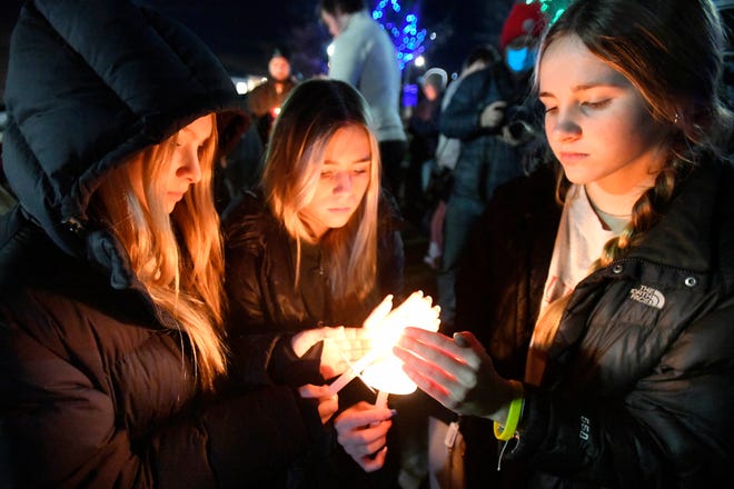 Lake Orion High School students (left to right) Hadley Socha, 15, Lilla Bonner, 15 and Layla Thompson, 15, light candles during a vigil in Children's Park in Lake Orion. "School should be a safe place to learn, you shouldn’t be scared to go," Thompson said.