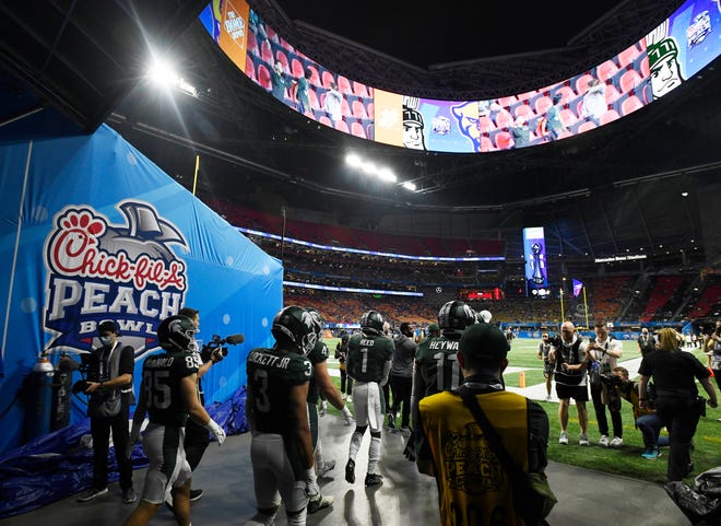 Michigan State players make their way onto the field at Mercedes Benz Stadium before the Peach Bowl against Pitt.