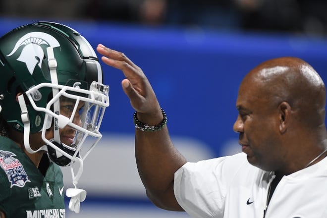 Michigan State’s Jalen Nailor gets a top on the helmet by head coach Mel Tucker on the field during warmups.