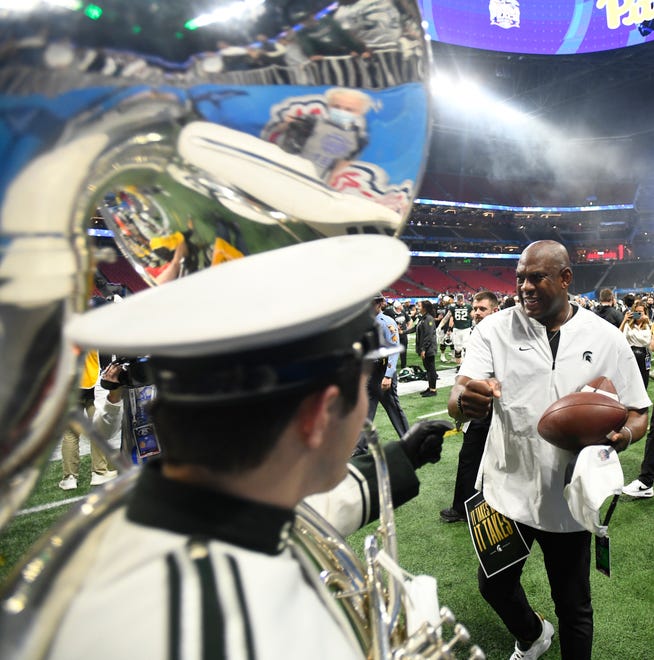MSU head coach Mel Tucker bumps fists with members of the MSU marching band after the Peach Bowl victory.