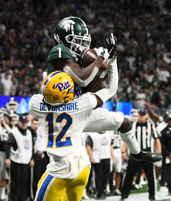 Michigan State wide receiver Jayden Reed hangs onto a touchdown reception over Pitt's M.J. Devonshire in the fourth quarter.