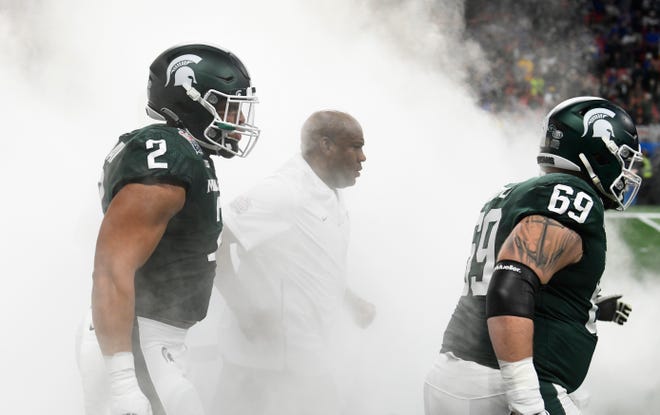 Head coach Mel Tucker and the Michigan State football team make their way through the smoke during introductions before the game.