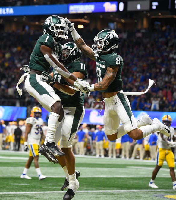 Michigan State's Jayden Reed (1), Connor Heyward and Jalen Nailor (8) celebrate Reed's long touchdown reception in the first quarter. Michigan State University and Pitt in the 2021 Peach Bowl at Mercedes Benz Stadium in Atlanta, Georgia on December 30, 2021.