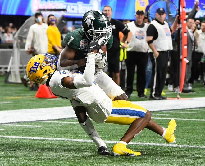 Michigan State wide receiver Jayden Reed hangs onto a touchdown reception over Pitt’s M.J. Devonshire in the fourth quarter.