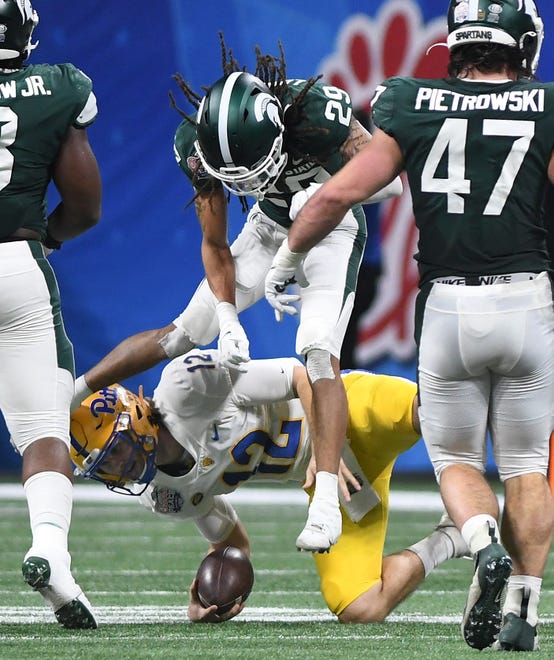 Pitt quarterback Nick Patti goes down with Michigan State's Marqui Lowery in the first quarter.