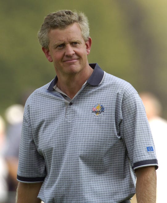 European team member Colin Montgomerie smiles (sort of) at the gallery around the 7th hole on day two of practice rounds at the Ryder Cup in 2004.