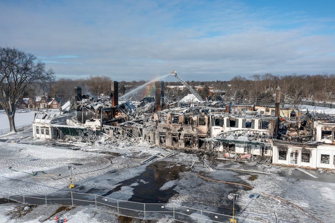 Firefighters continue to pour water on the historic Oakland Hills Country Club, Friday morning, Feb. 18, 2022, the day after a devastating fire.