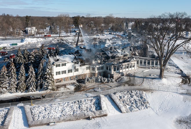 Firefighters continue to pour water on the Oakland Hills Country Club on Friday, Feb. 18, 2022, a day after a massive fire ripped through the clubhouse.