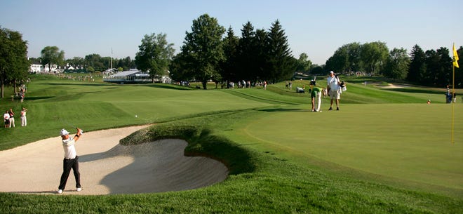 The Oakland Hills clubhouse adorns the background as Anthony Kim hits a shot out of the sand onto the 10th green Thursday at Oakland Hills during the first round of the PGA championship in 2008